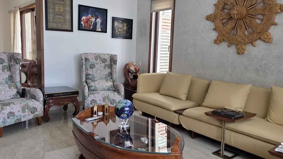 Residential living room with custom mustard velvet sofa set, printed wingback accent chair and a solid-wood boat-shaped coffee table — a space planned around daily use — Flamingo Lifestyles Bengaluru